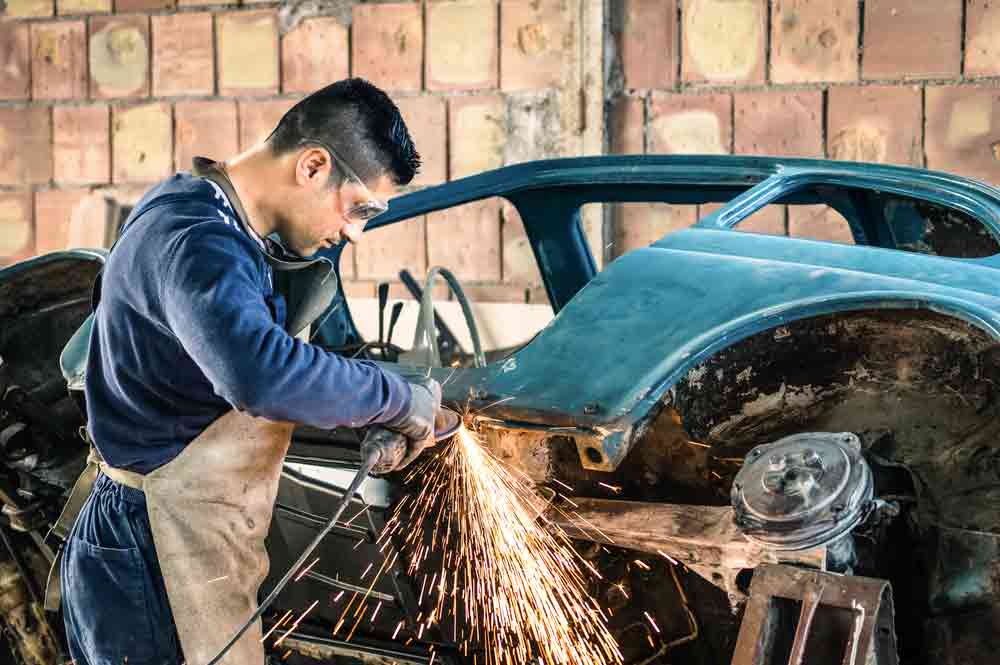 A Mechanical Worker on the Central Coast with Business Insurance Repairing a car
